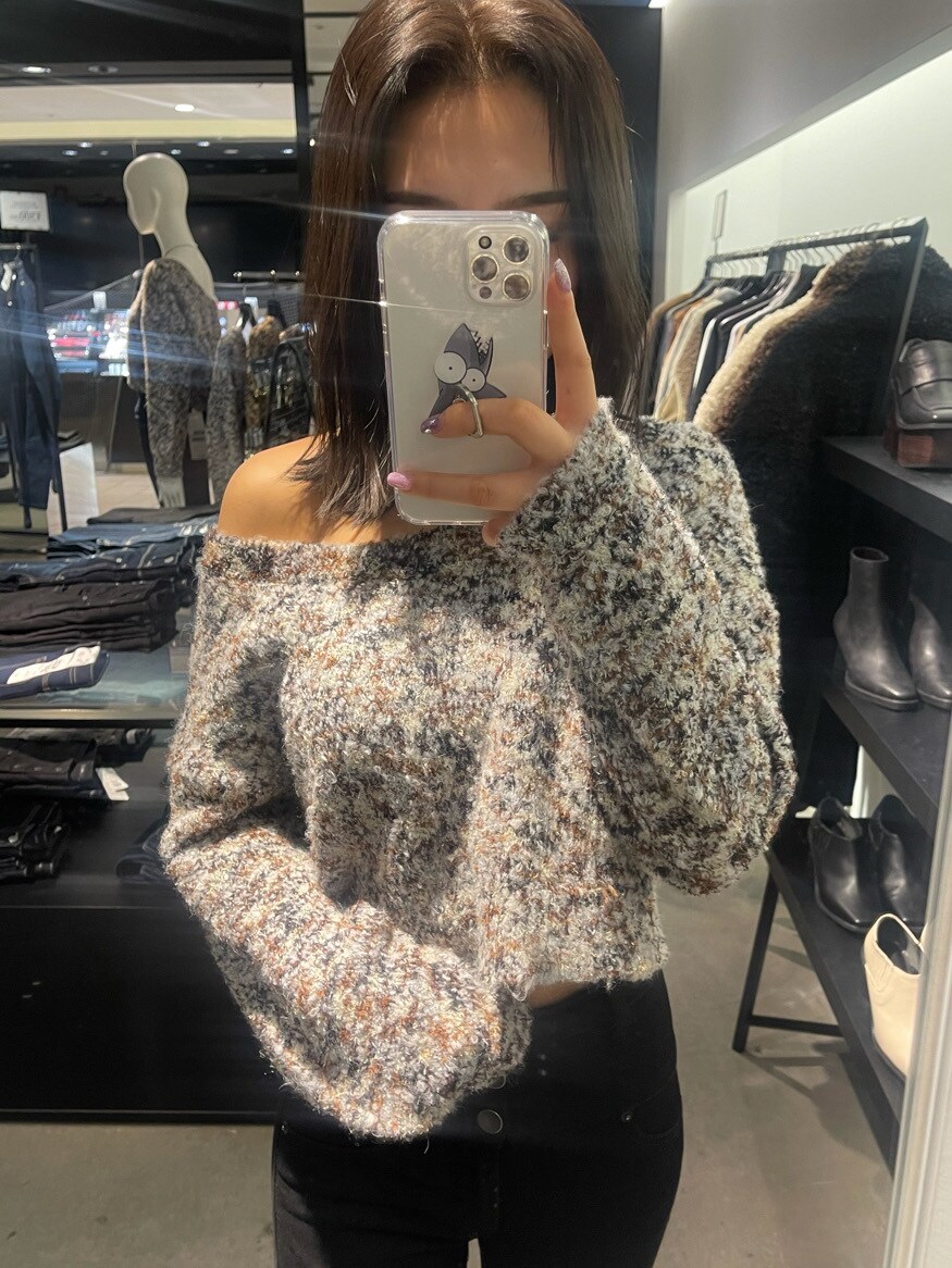 ブラック系のブーツ、ブラック系のデニムパンツ、ホワイト系のニット/セーターを着用したレディースの冬コーディネートの2枚目の写真