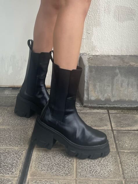 ブラック系のブーツ、ブラック系のスカート、ブラック系のニット/セーターを着用したレディースの夏コーディネートの7枚目の写真