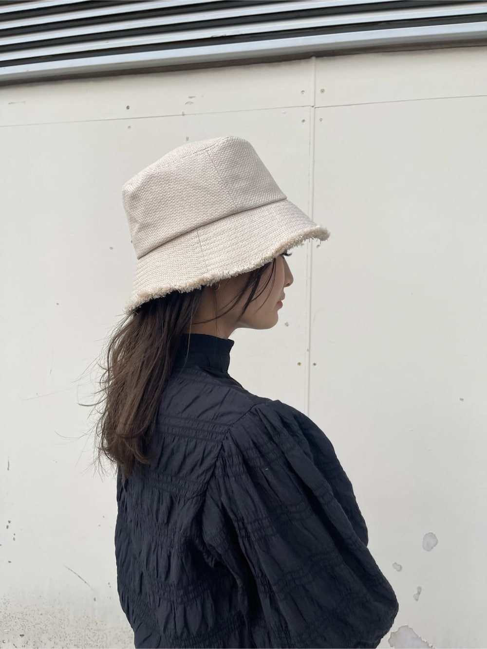 ホワイト系のブーツ、ブラウン系のハンドバッグ、ブラック系のシャツ/ブラウスを着用したレディースの春コーディネートの6枚目の写真