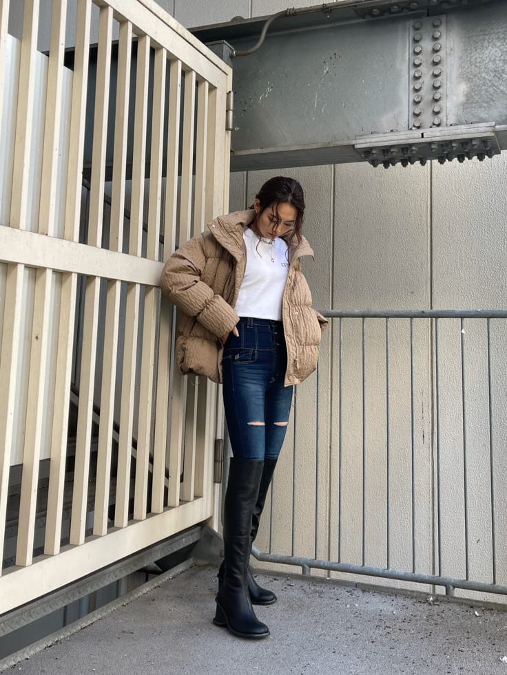 ブルー系のデニムパンツ、ブラック系のブーツ、ホワイト系のTシャツ/カットソーを着用したレディースの秋コーディネートの3枚目の写真