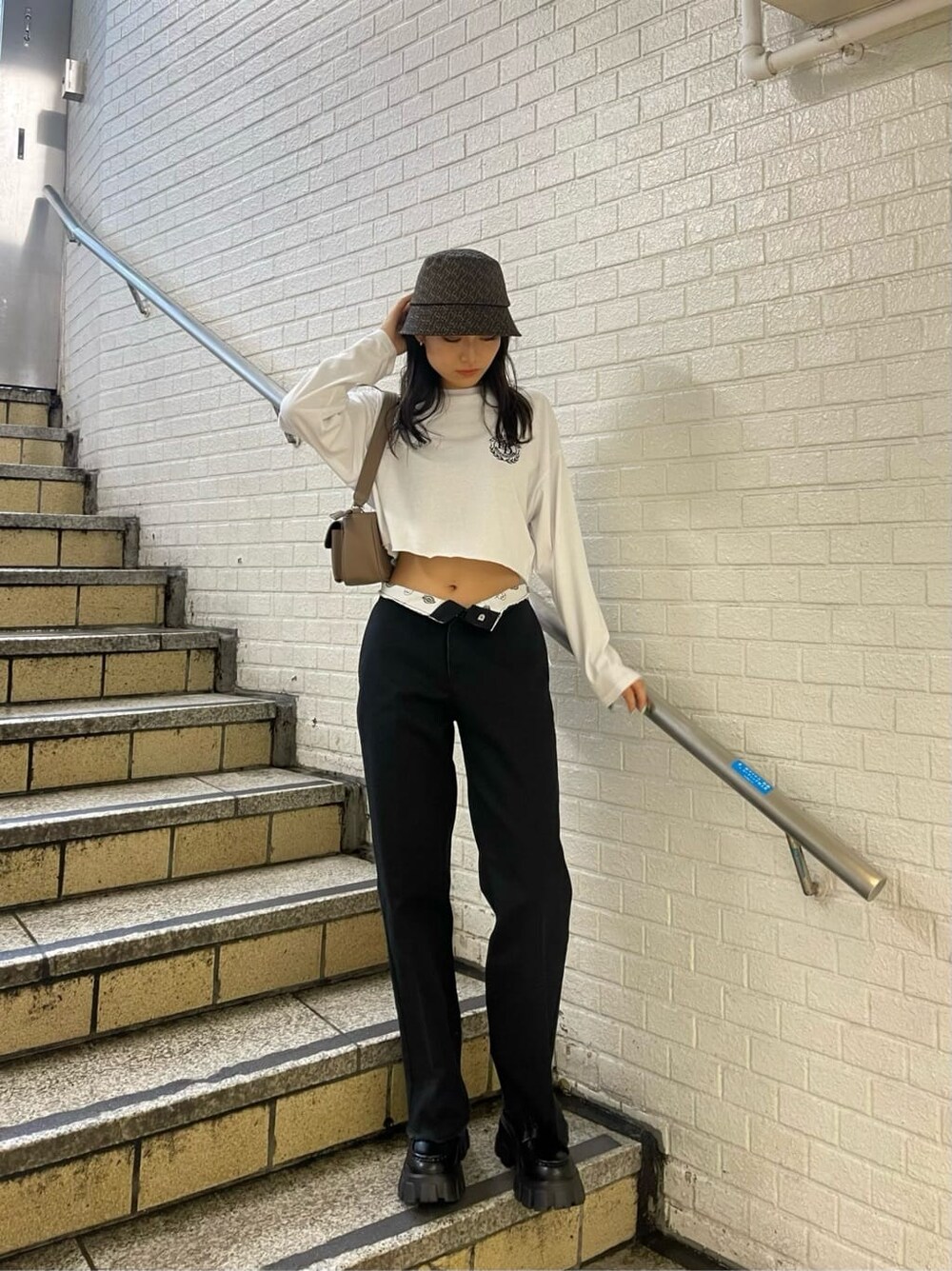 ブラック系のローファー、ブラック系のローファー、ブラウン系のハンドバッグを着用したレディースの秋コーディネートの2枚目の写真