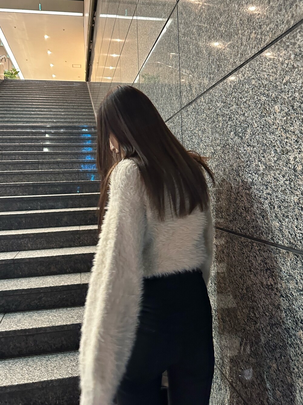 ブラック系のデニムパンツ、ベージュ系のニット/セーター、ブラック系のブーツを着用したレディースの冬コーディネートの5枚目の写真