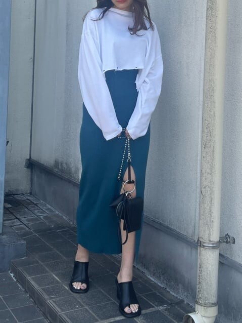 ブラック系のハンドバッグ、ホワイト系のTシャツ/カットソー、ブラック系のサンダルを着用したレディースの春コーディネートの5枚目の写真