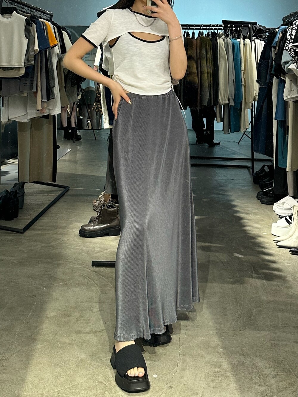 グレー系のスカート、ブラック系のサンダル、ホワイト系のTシャツ/カットソーを着用したレディースの夏コーディネートの3枚目の写真