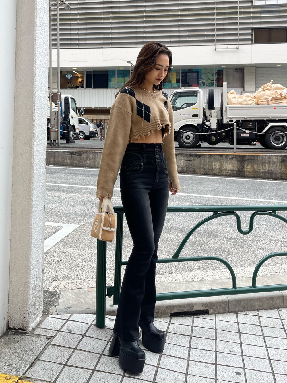 その他のニット/セーター、ベージュ系のハンドバッグ、ブラック系のブーツを着用したレディースの冬コーディネートの2枚目の写真