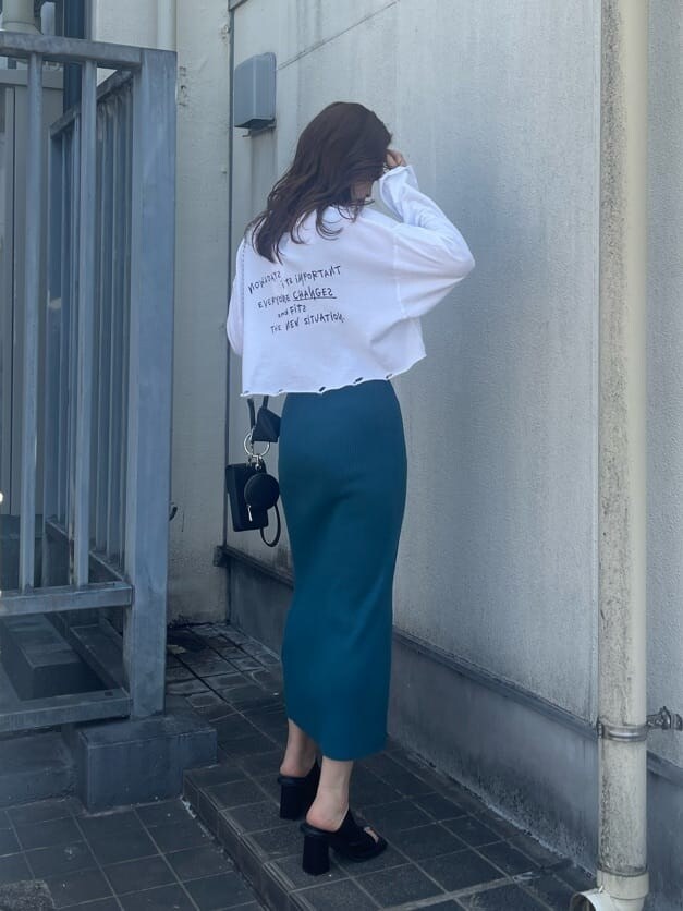 ブラック系のハンドバッグ、ホワイト系のTシャツ/カットソー、ブラック系のサンダルを着用したレディースの春コーディネートの4枚目の写真