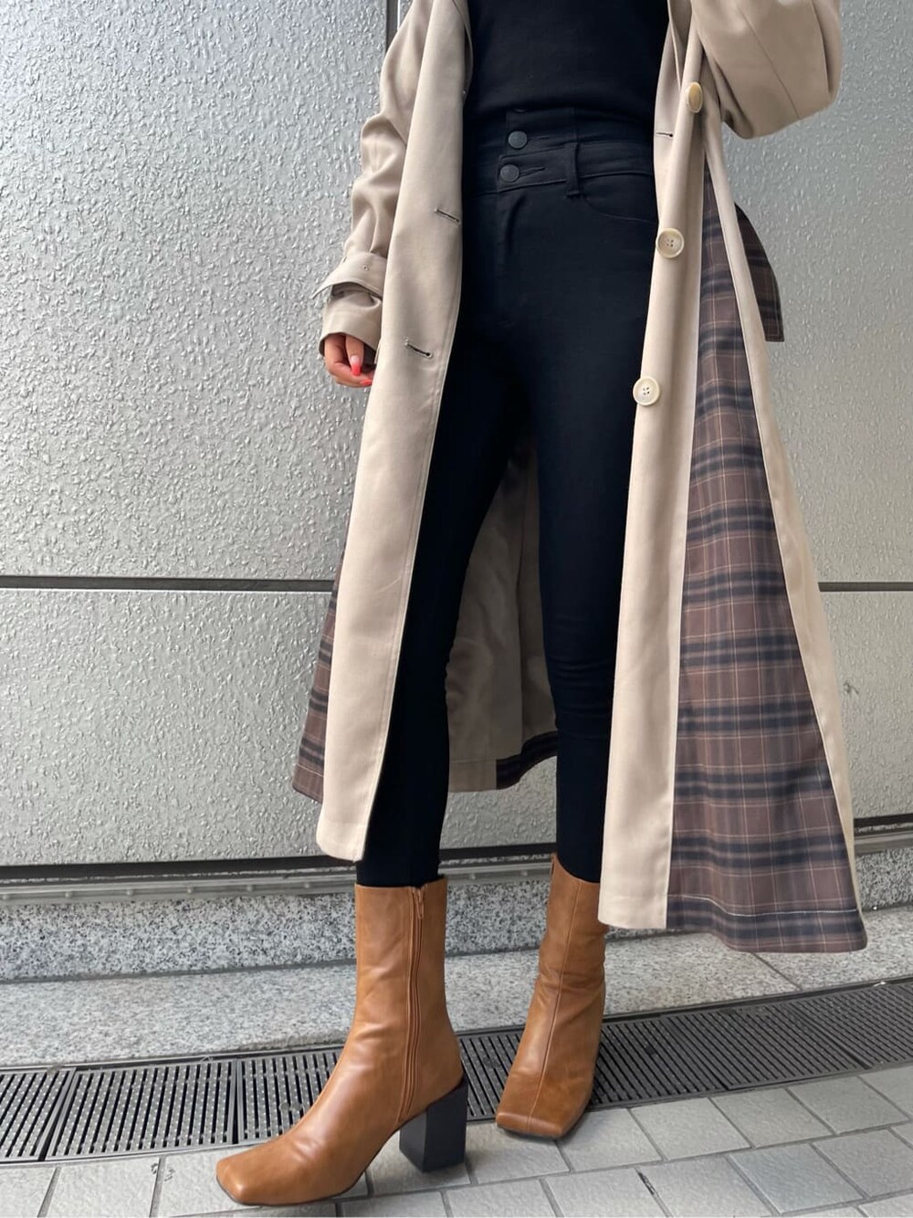 ベージュ系のトレンチコート、ブラック系のTシャツ/カットソー、ブラック系のデニムパンツを着用したレディースの夏コーディネートの6枚目の写真