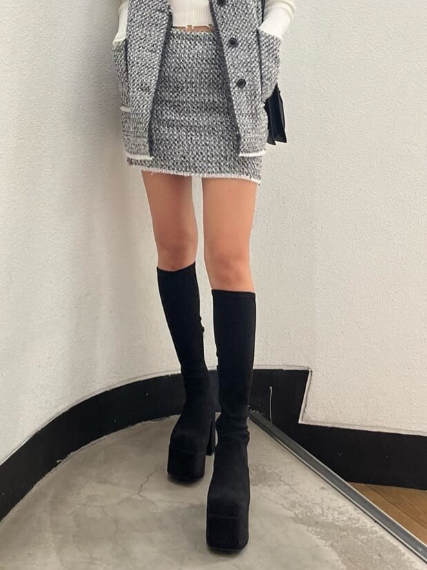 ホワイト系のニット/セーター、ブラック系のブーツ、グレー系のベストを着用したレディースの秋コーディネートの7枚目の写真