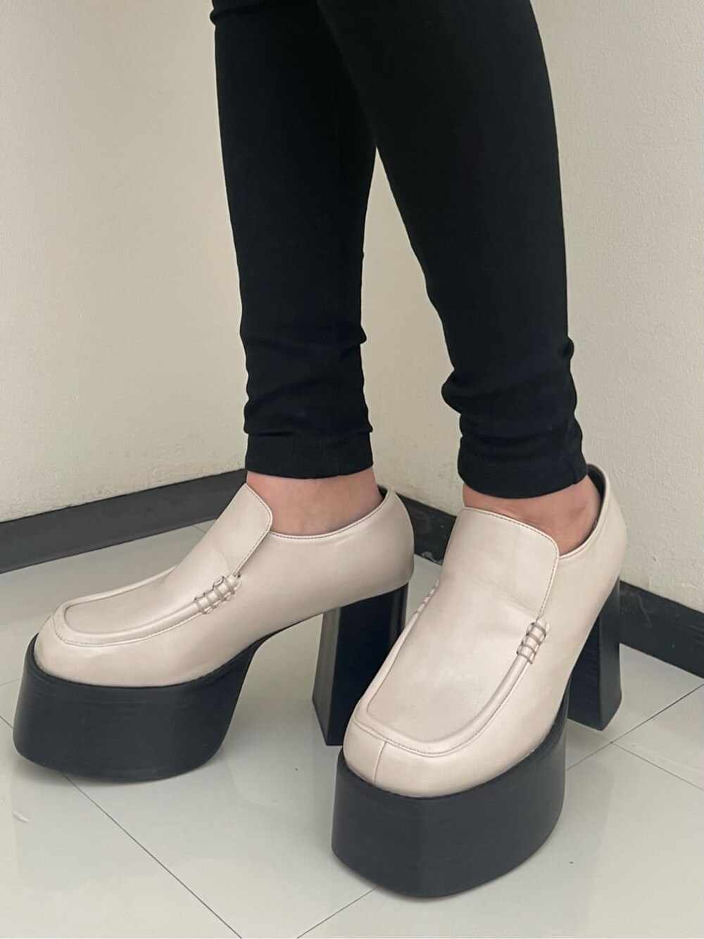 ホワイト系のローファー、ブラック系のハンドバッグ、ブラック系のデニムパンツを着用したレディースの春コーディネートの6枚目の写真