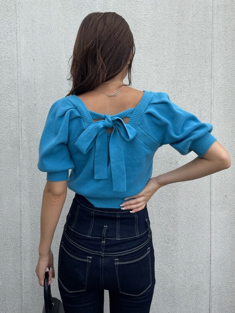 ブラック系のハンドバッグ、ブルー系のデニムパンツ、ブルー系のニット/セーターを着用したレディースの秋コーディネートの4枚目の写真