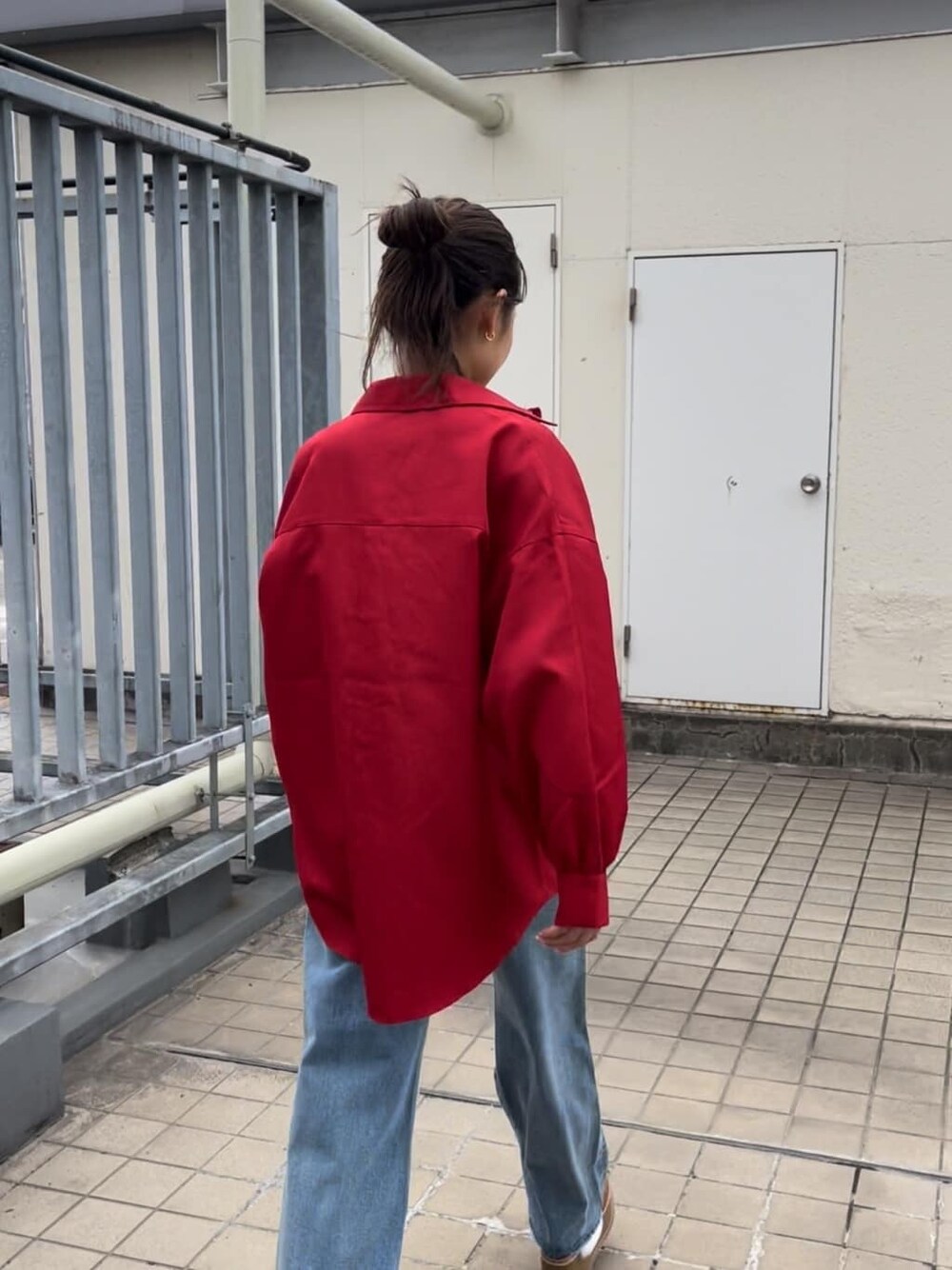 ブルー系のデニムパンツ、ベージュ系のスリッポン、レッド系のシャツ/ブラウスを着用したレディースの秋コーディネートの6枚目の写真