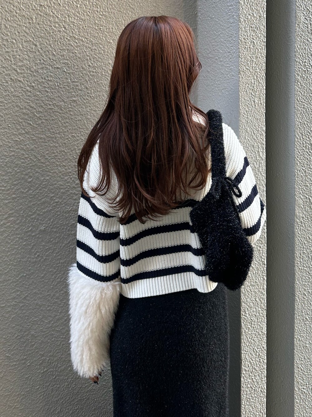 ブラック系のスカート、ブルー系のニット/セーターを着用したレディースの秋コーディネートの6枚目の写真