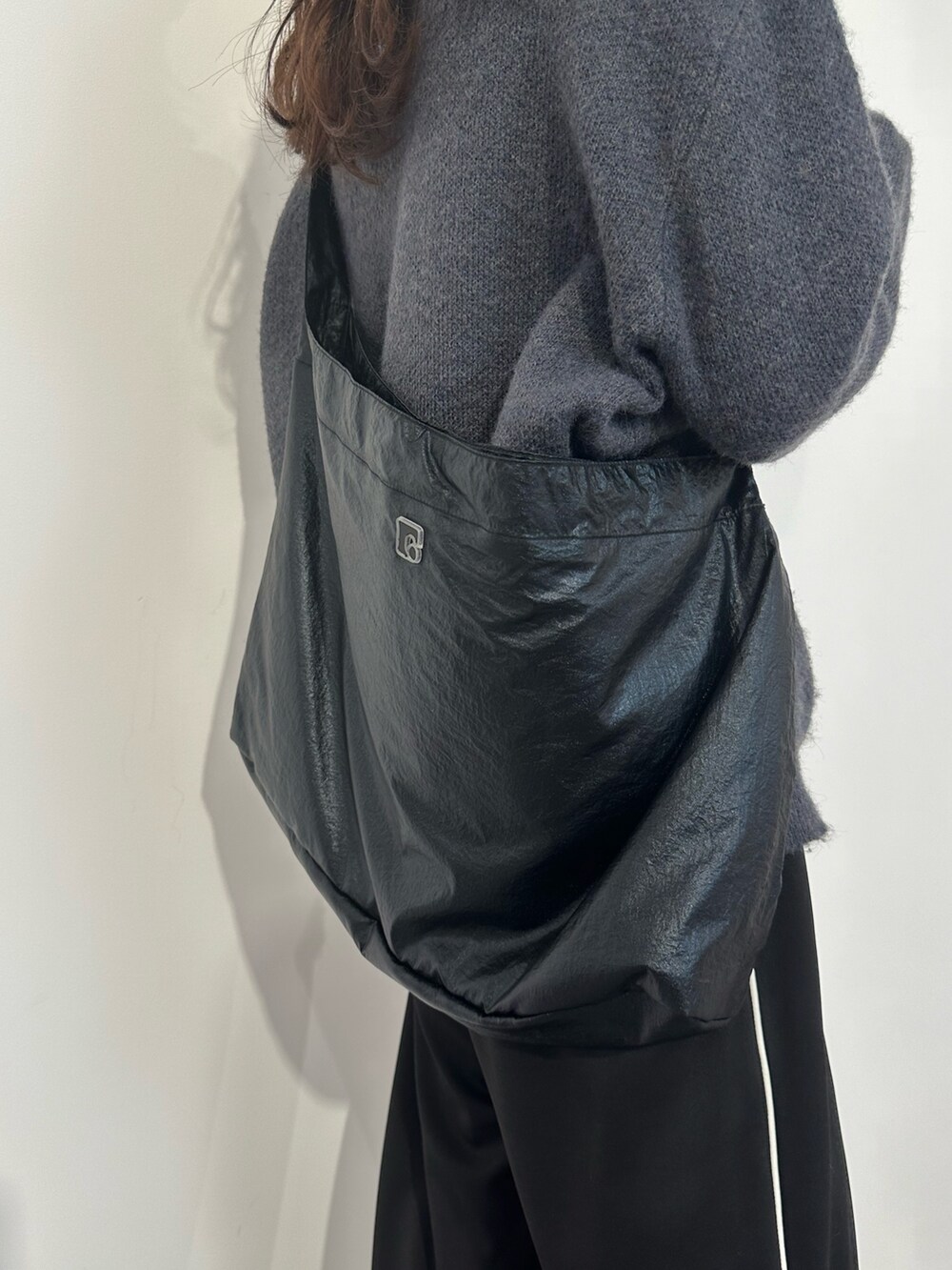 ブルー系のニット/セーター、ブラック系のスラックス、ブラック系のブーツを着用したレディースの冬コーディネートの5枚目の写真