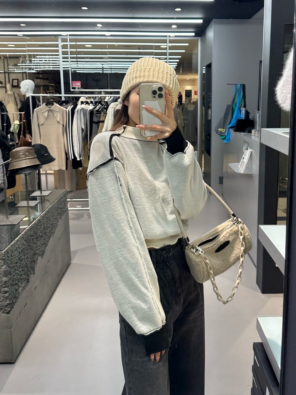 ブラック系のデニムパンツ、ホワイト系のハンドバッグ、ブラック系のローファーを着用したレディースの冬コーディネートの6枚目の写真