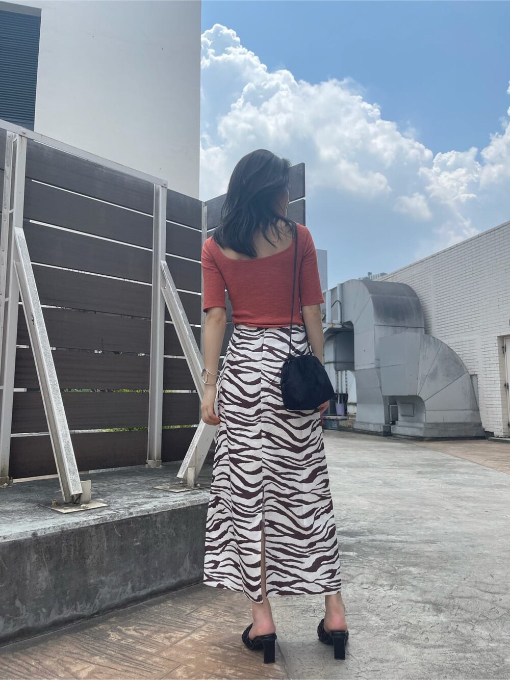 その他のスカート、ブラック系のハンドバッグ、ブラック系のサンダルを着用したレディースの夏コーディネートの2枚目の写真