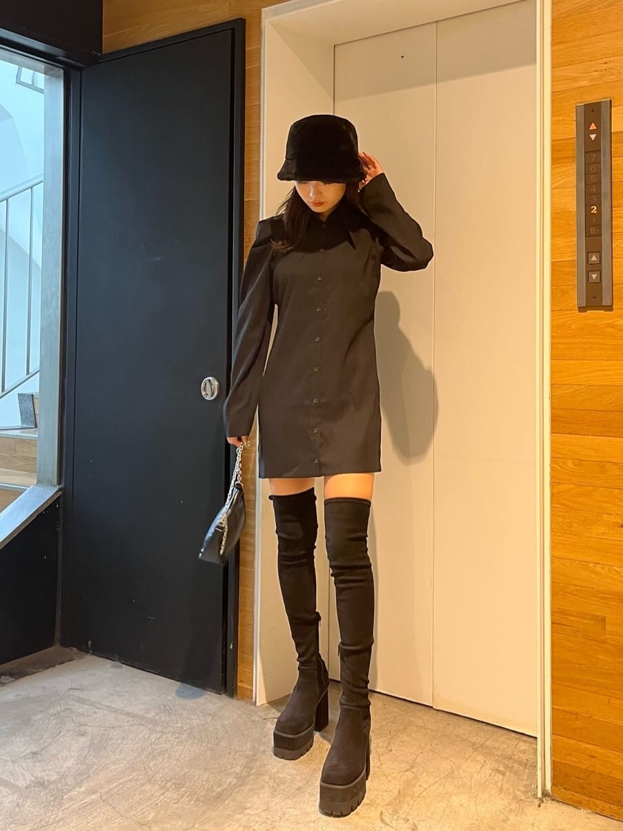 ブラック系のワンピース、ブラック系のブーツ、ブラック系のハンドバッグを着用したレディースの秋コーディネートの2枚目の写真