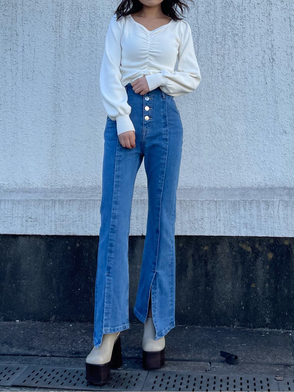 グリーン系のトレンチコート、ホワイト系のサンダル、ブルー系のデニムパンツを着用したレディースの春コーディネートの6枚目の写真