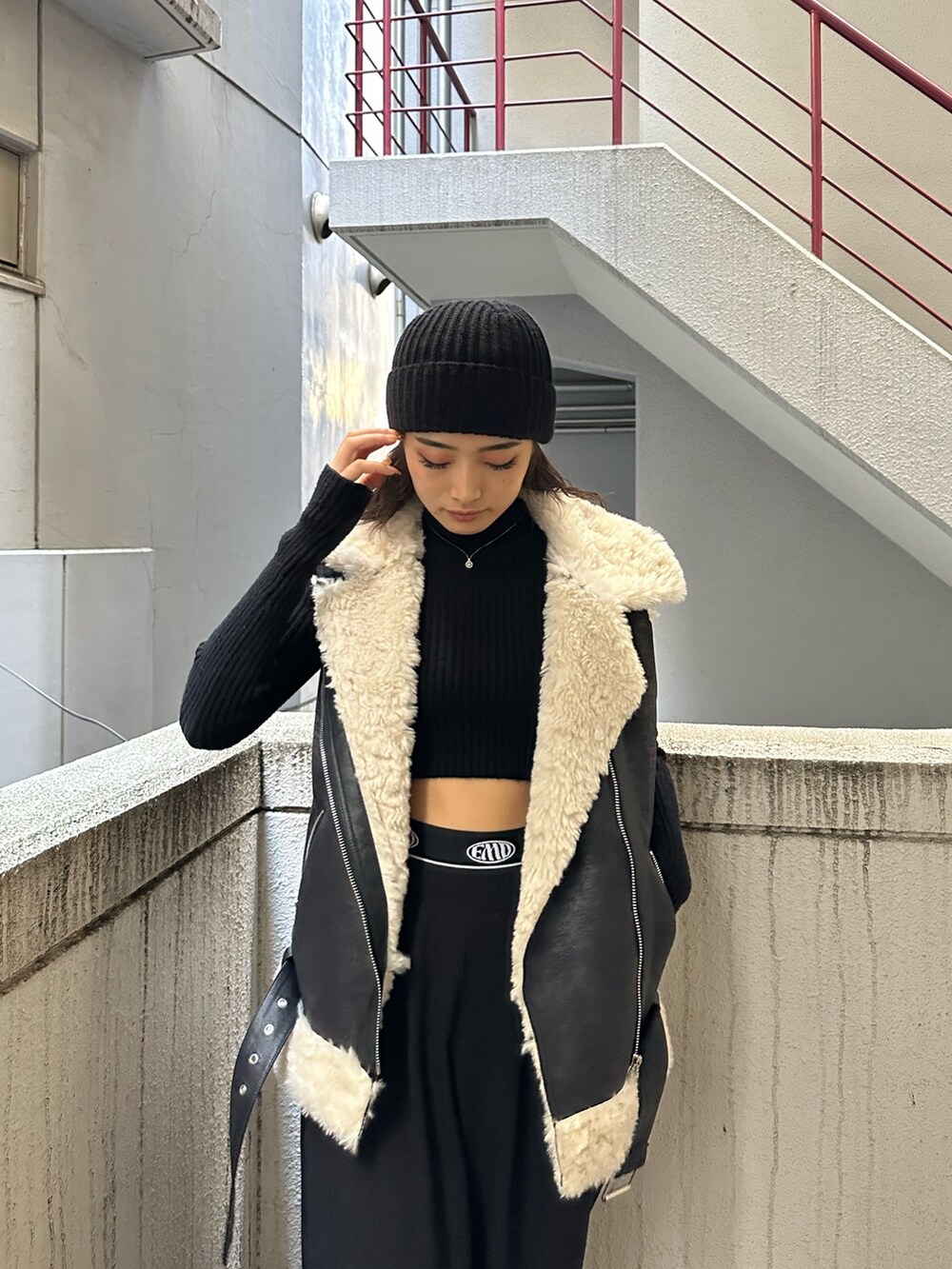 ブラック系のその他パンツ、ブラック系のブーツ、ブラック系のムートンコートを着用したレディースの秋コーディネートの4枚目の写真
