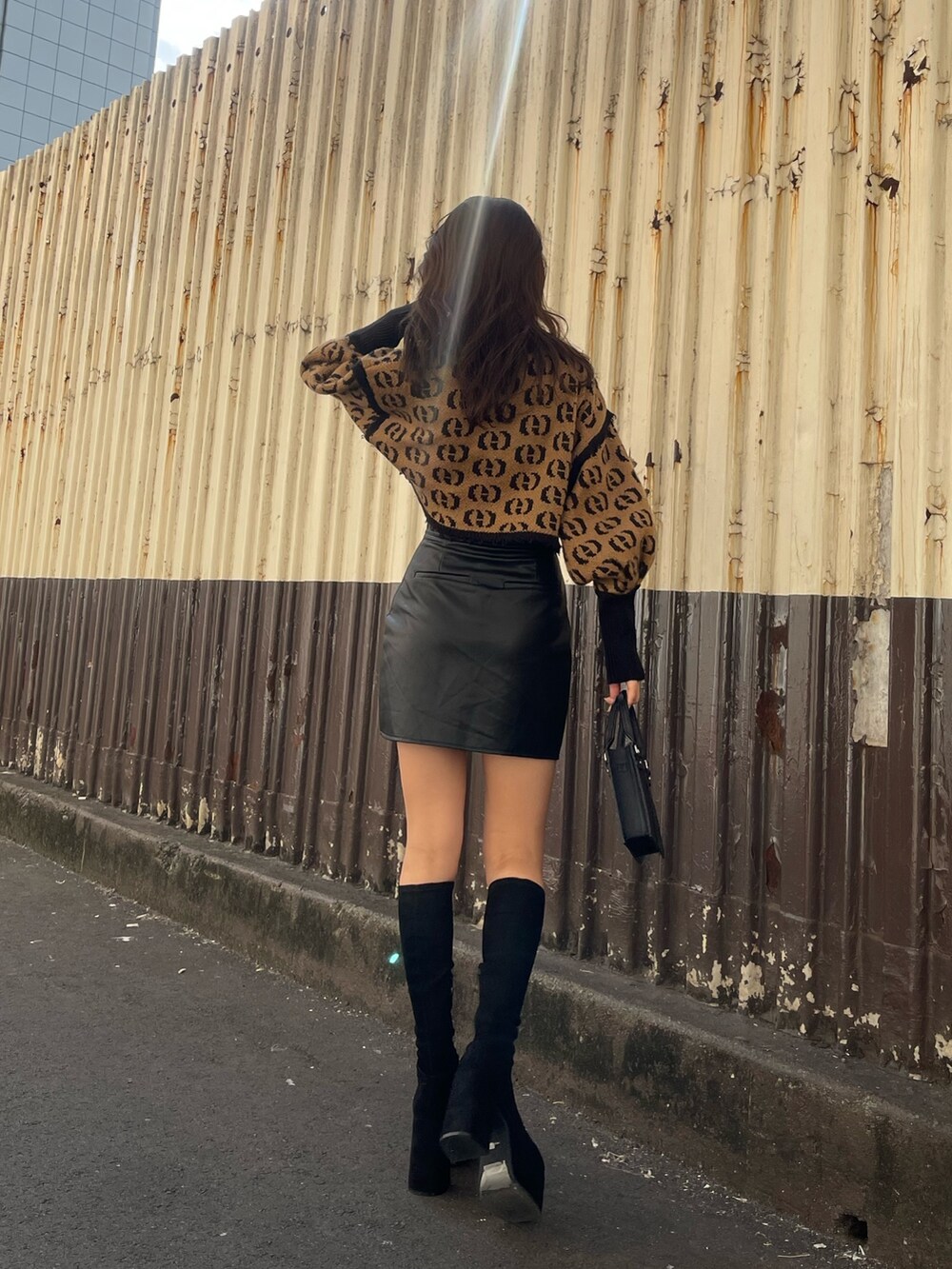 その他のニット/セーター、その他のスカート、ブラック系のハンドバッグを着用したレディースの秋コーディネートの3枚目の写真