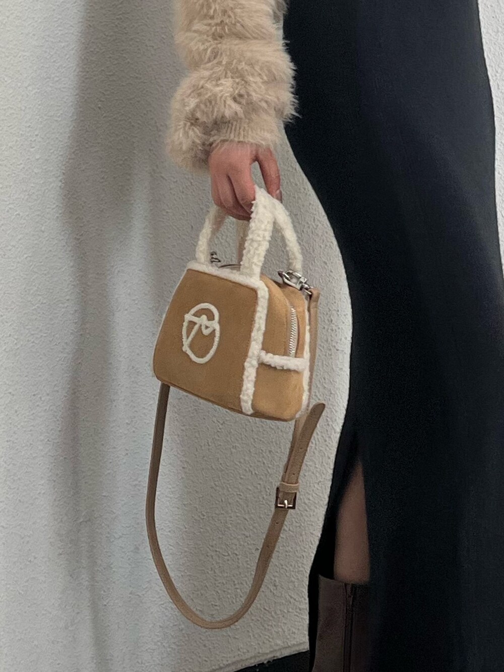 ホワイト系のニット/セーター、ベージュ系のハンドバッグ、ブラウン系のブーツを着用したレディースの秋コーディネートの7枚目の写真