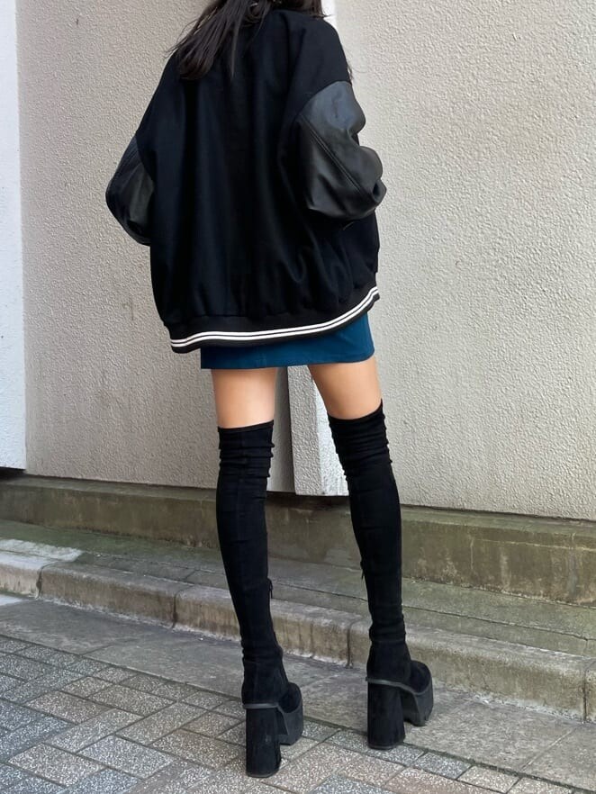 ブラック系のブーツ、ブルー系のスカート、ブラック系のブルゾンを着用したレディースの秋コーディネートの3枚目の写真