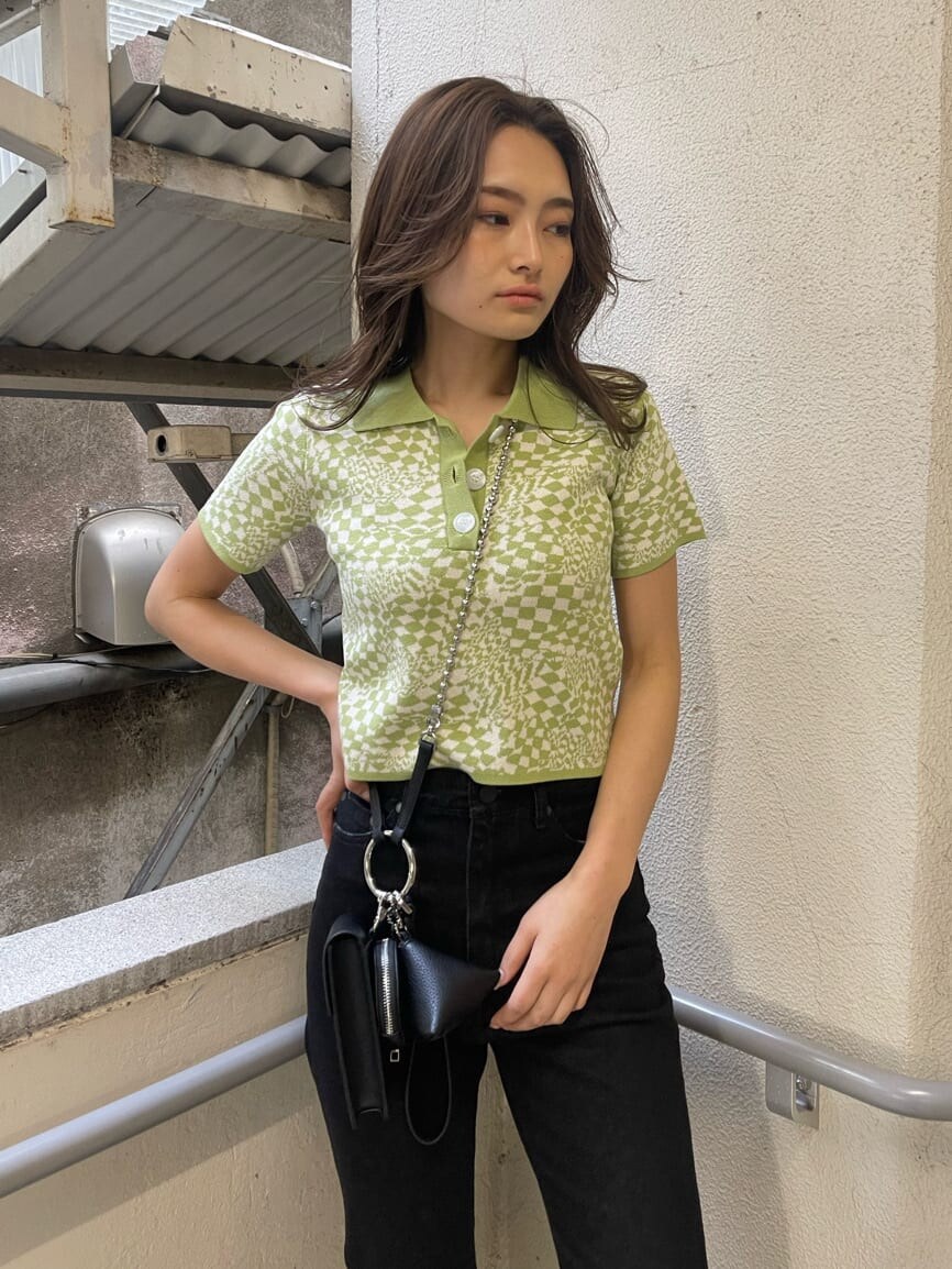 ブラック系のブーツ、ブラック系のハンドバッグ、ブラック系のデニムパンツを着用したレディースの春コーディネートの6枚目の写真