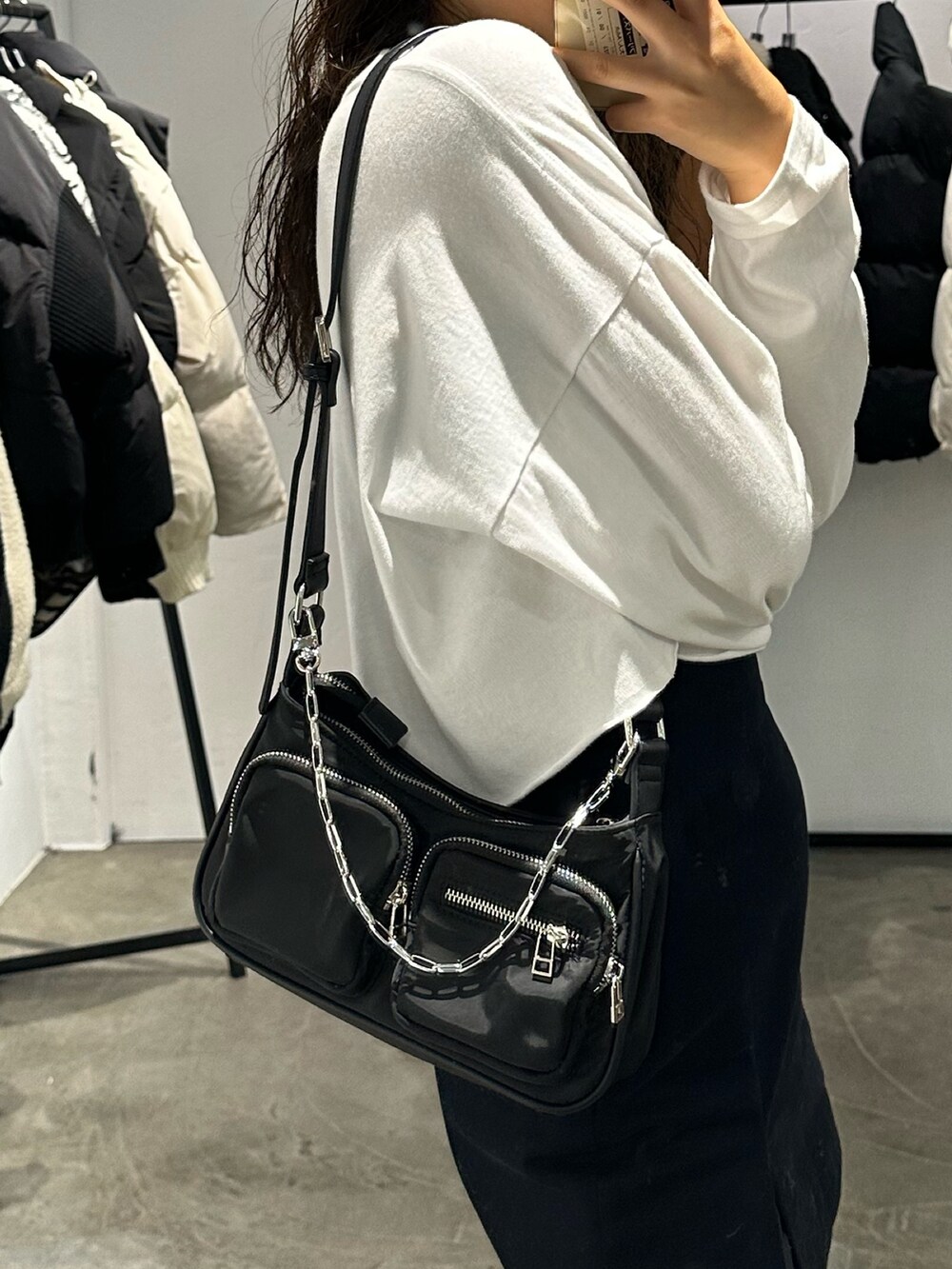 ブラック系のブーツ、ブラック系のスカート、ホワイト系のTシャツ/カットソーを着用したレディースの秋コーディネートの6枚目の写真