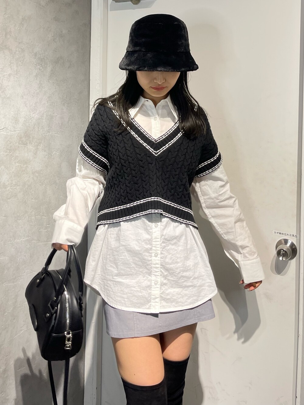 ブラック系のブーツ、ブラック系のベスト、ホワイト系のシャツ/ブラウスを着用したレディースの冬コーディネートの6枚目の写真