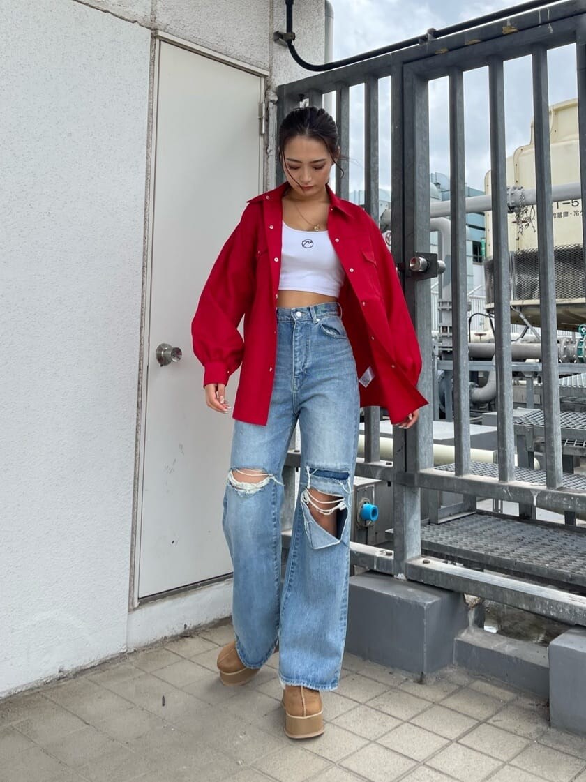 ブルー系のデニムパンツ、ベージュ系のスリッポン、レッド系のシャツ/ブラウスを着用したレディースの秋コーディネートの3枚目の写真