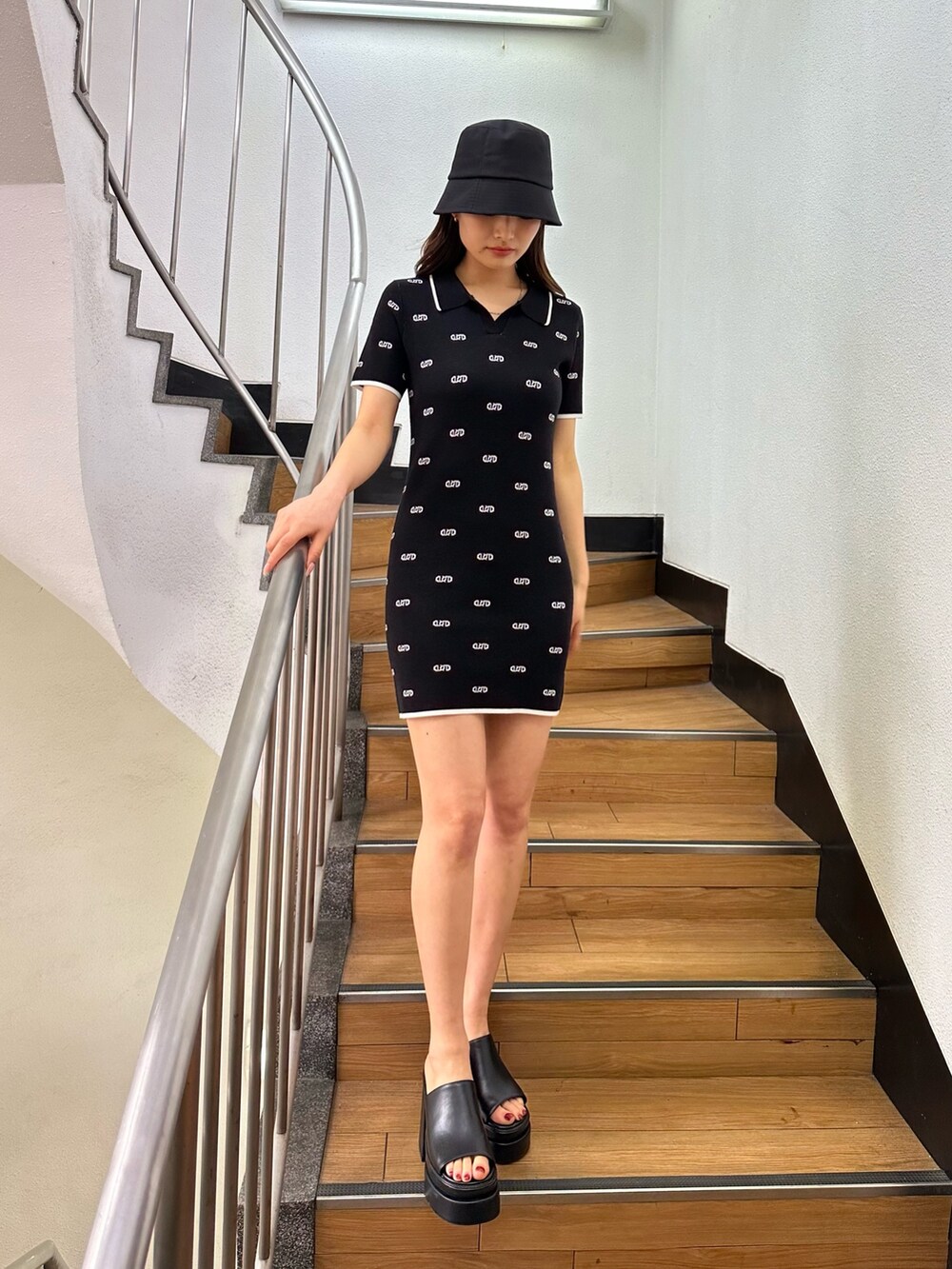 ブラック系のワンピース、ブラック系のサンダル、ブラック系のハットを着用したレディースの春コーディネートの2枚目の写真