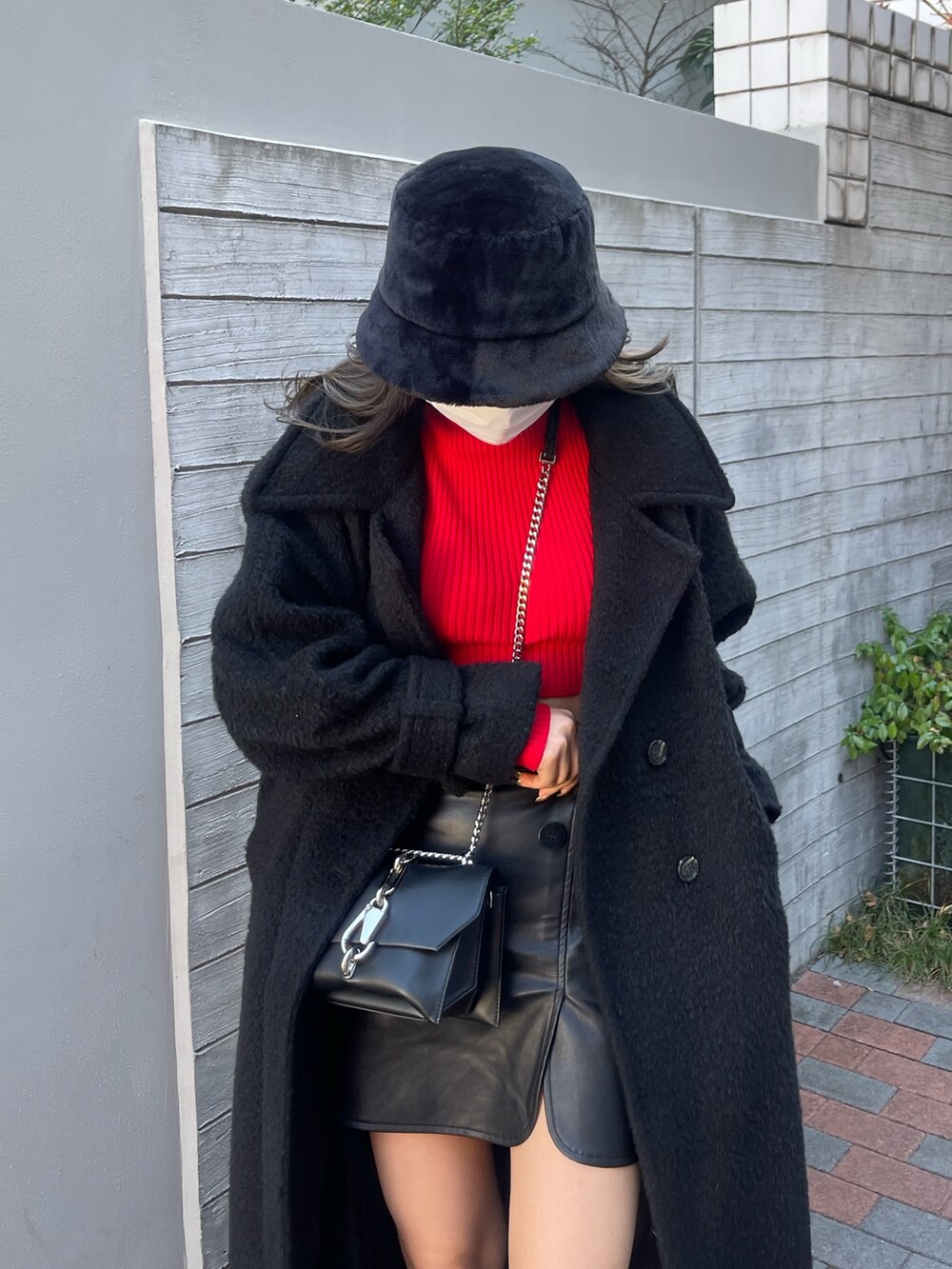 ブラック系のチェスターコート、その他のスカート、レッド系のニット/セーターを着用したレディースの冬コーディネートの8枚目の写真