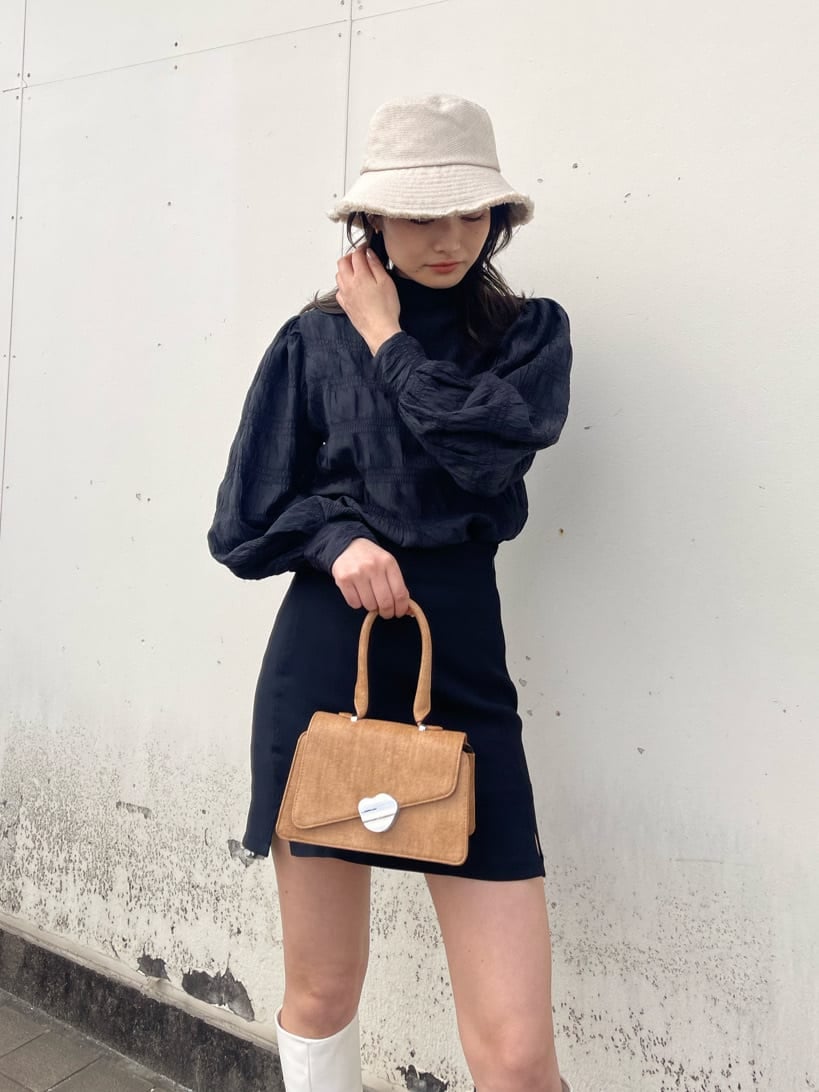 ホワイト系のブーツ、ブラウン系のハンドバッグ、ブラック系のシャツ/ブラウスを着用したレディースの春コーディネートの4枚目の写真