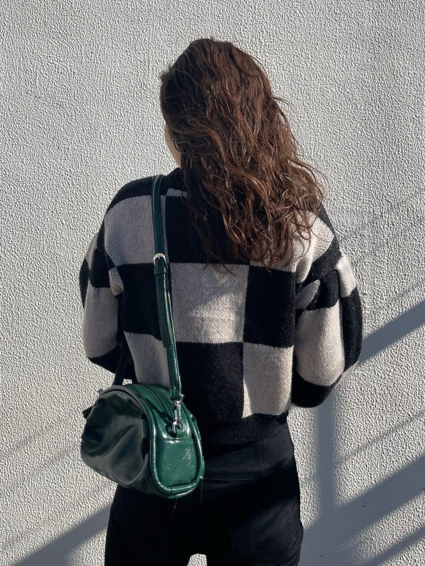 ブラック系のデニムパンツ、グリーン系のボディバッグ/ウエストポーチ、ブラック系のカーディガン/ボレロを着用したレディースの冬コーディネートの4枚目の写真