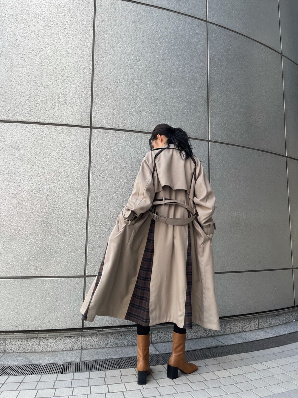 ベージュ系のトレンチコート、ブラック系のTシャツ/カットソー、ブラック系のデニムパンツを着用したレディースの夏コーディネートの2枚目の写真