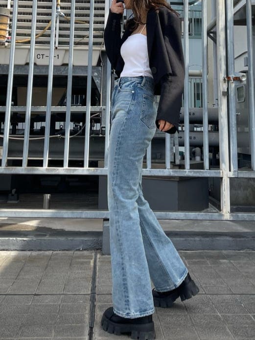 ブラック系のテーラードジャケット、ブルー系のデニムパンツ、ブラック系のブーツを着用したレディースの春コーディネートの4枚目の写真