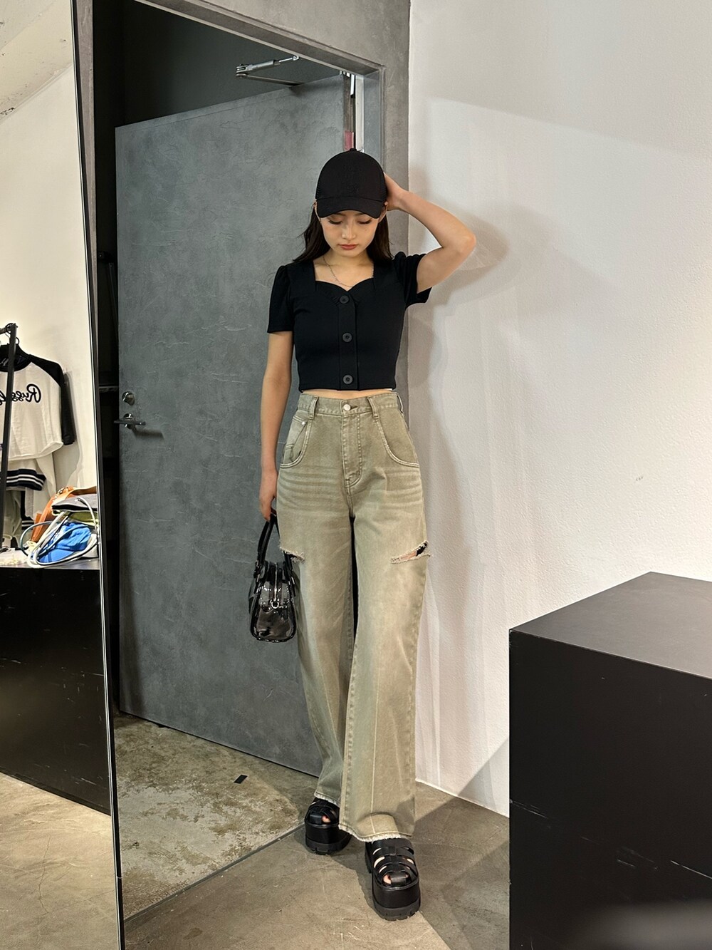 ベージュ系のデニムパンツ、その他のハンドバッグ、ブラック系のTシャツ/カットソーを着用したレディースの春コーディネートの2枚目の写真