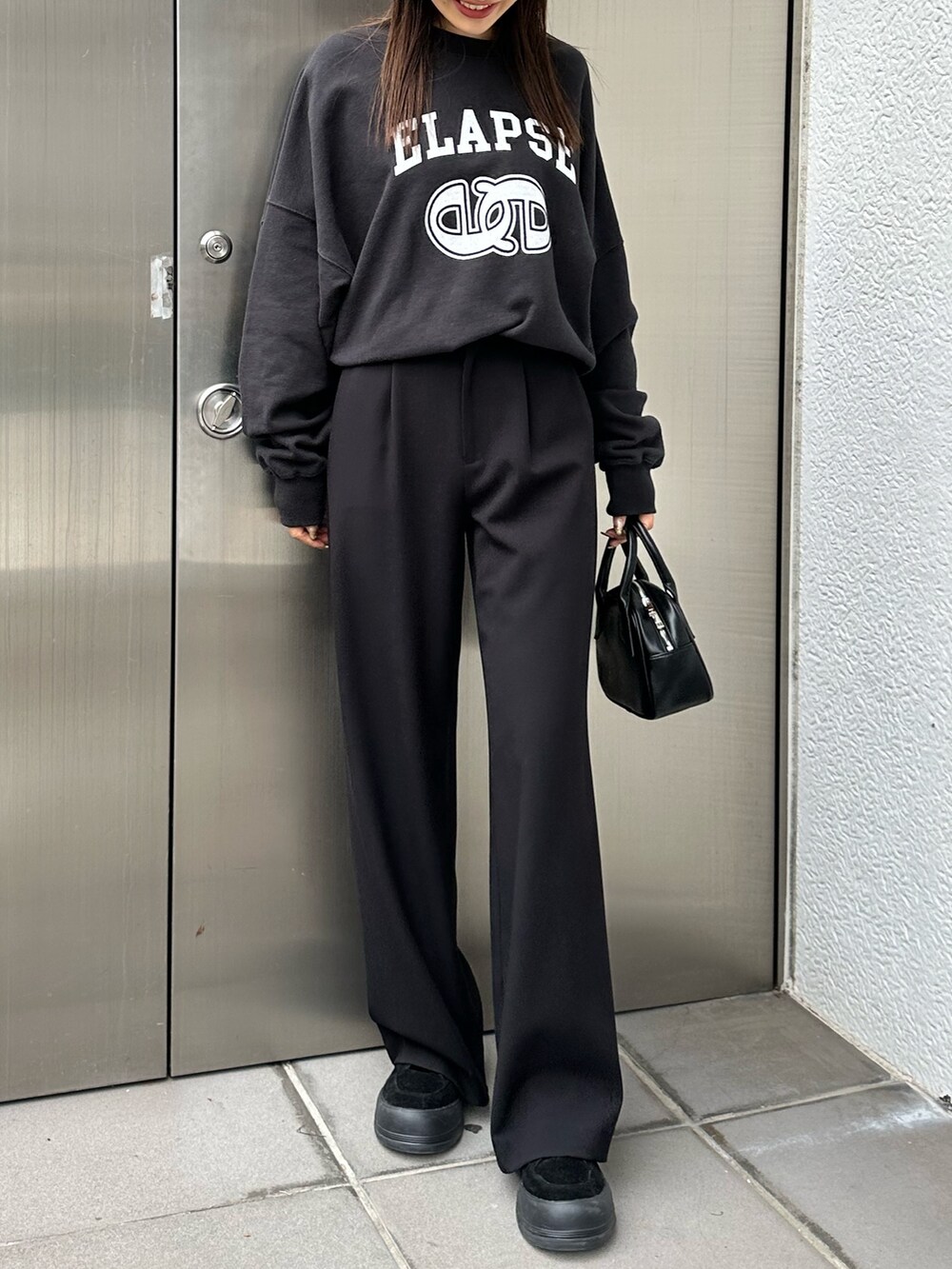 ブラック系のその他パンツ、ブラック系のハンドバッグ、ブラック系のTシャツ/カットソーを着用したレディースの冬コーディネートの3枚目の写真