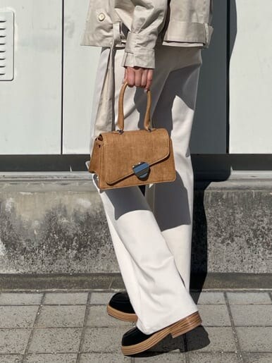 ベージュ系のトレンチコート、ホワイト系のその他パンツ、ブラウン系のハンドバッグを着用したレディースの冬コーディネートの8枚目の写真