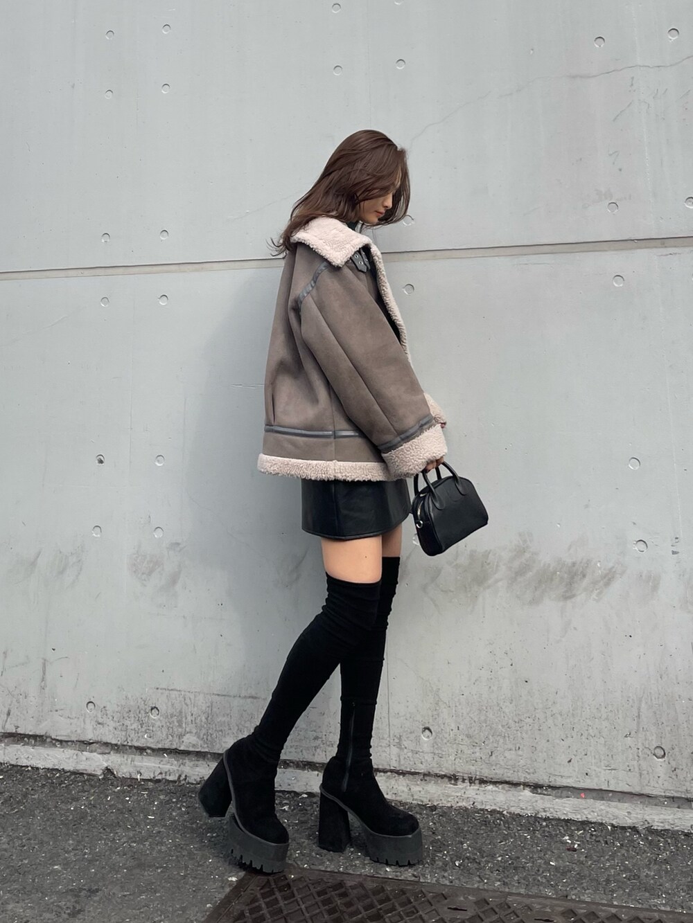 グレー系のブルゾン、その他のスカート、ブラック系のブーツを着用したレディースの秋コーディネートの2枚目の写真
