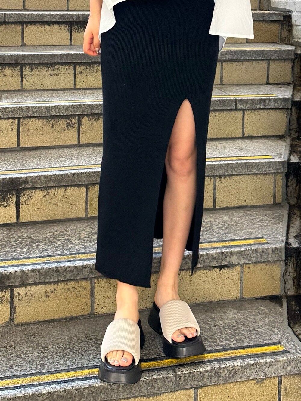 ブラック系のワンピース、ホワイト系のシャツ/ブラウス、ホワイト系のサンダルを着用したレディースの春コーディネートの7枚目の写真