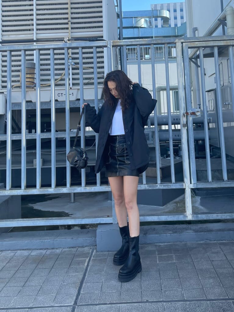 ブラック系のブルゾン、ブラック系のスカート、ホワイト系のTシャツ/カットソーを着用したレディースの秋コーディネートの2枚目の写真