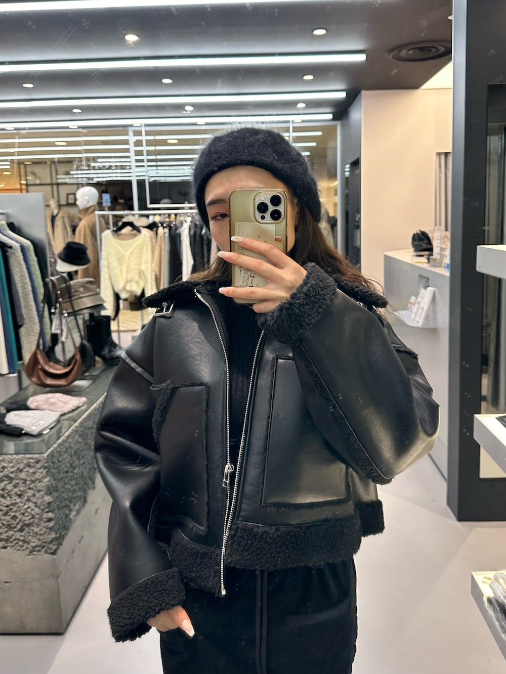 ブラック系のブルゾン、ブラック系のニット/セーター、ブラック系のブーツを着用したレディースの冬コーディネートの5枚目の写真