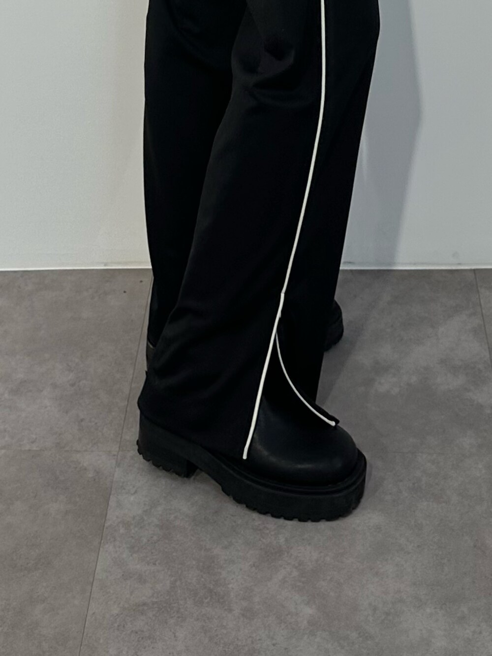 ブルー系のニット/セーター、ブラック系のスラックス、ブラック系のブーツを着用したレディースの冬コーディネートの7枚目の写真