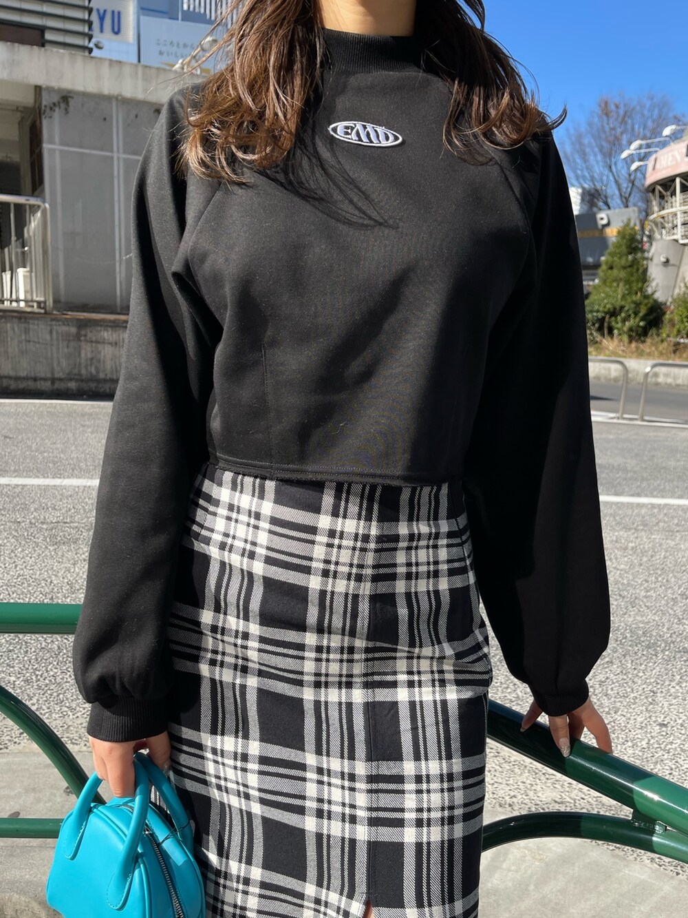 その他のスカート、ブラック系のスウェット、ブルー系のハンドバッグを着用したレディースの冬コーディネートの5枚目の写真