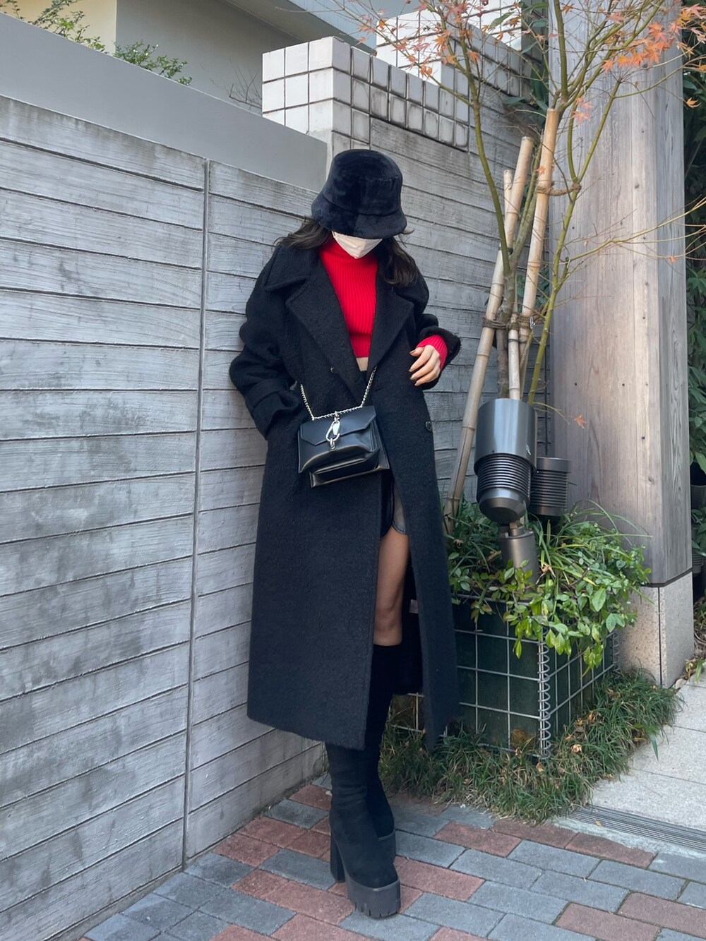 ブラック系のチェスターコート、その他のスカート、レッド系のニット/セーターを着用したレディースの冬コーディネートの2枚目の写真
