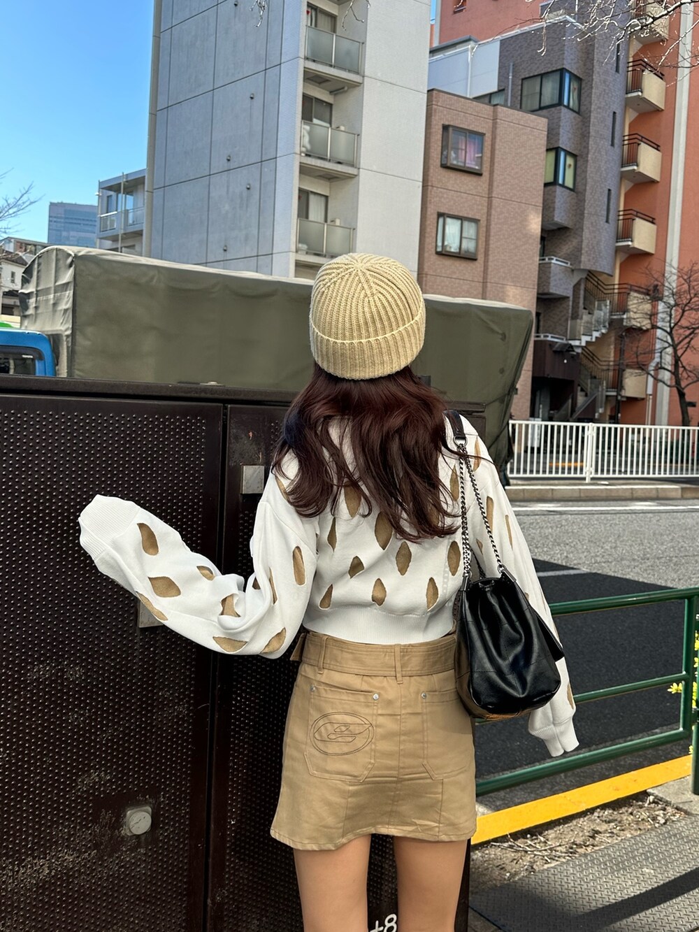 ベージュ系のスカート、ブラック系のブーツ、ホワイト系のニット/セーターを着用したレディースの冬コーディネートの3枚目の写真