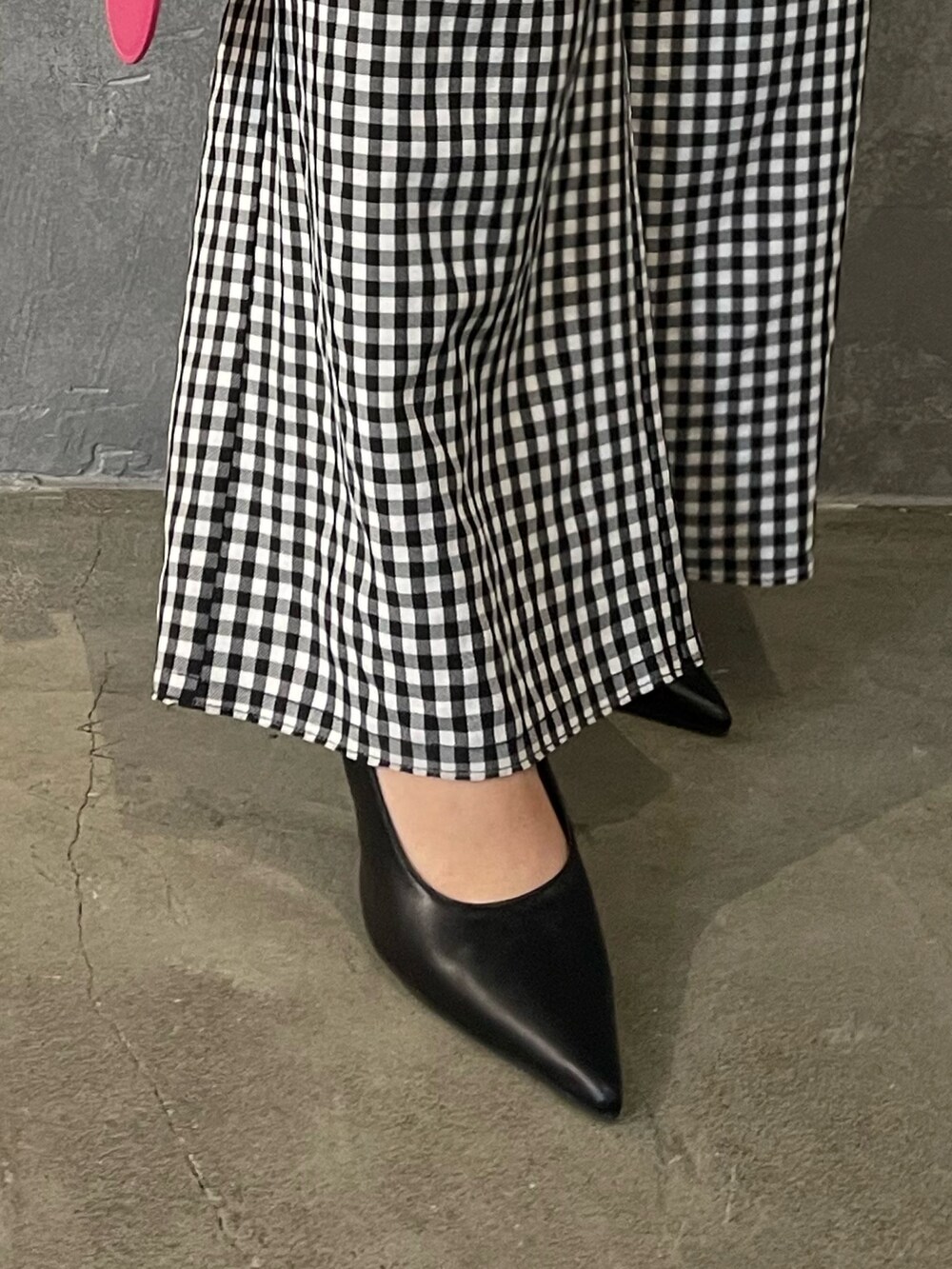 ピンク系のハンドバッグ、ブラック系のパンプス、ブラック系のテーラードジャケットを着用したレディースの冬コーディネートの7枚目の写真