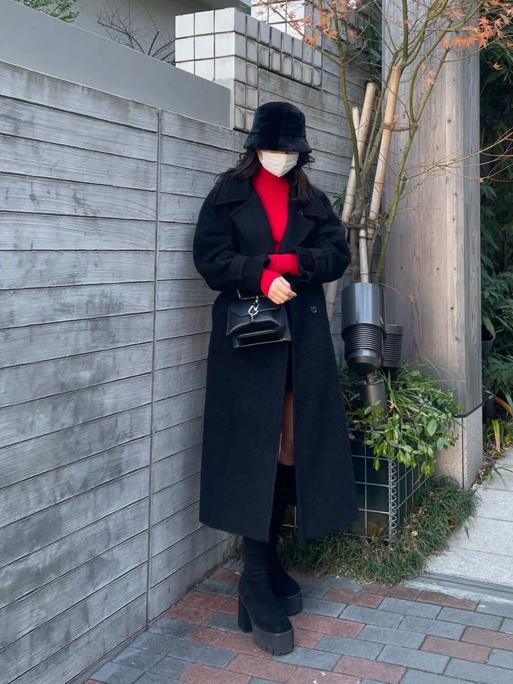 ブラック系のチェスターコート、その他のスカート、レッド系のニット/セーターを着用したレディースの冬コーディネートの3枚目の写真