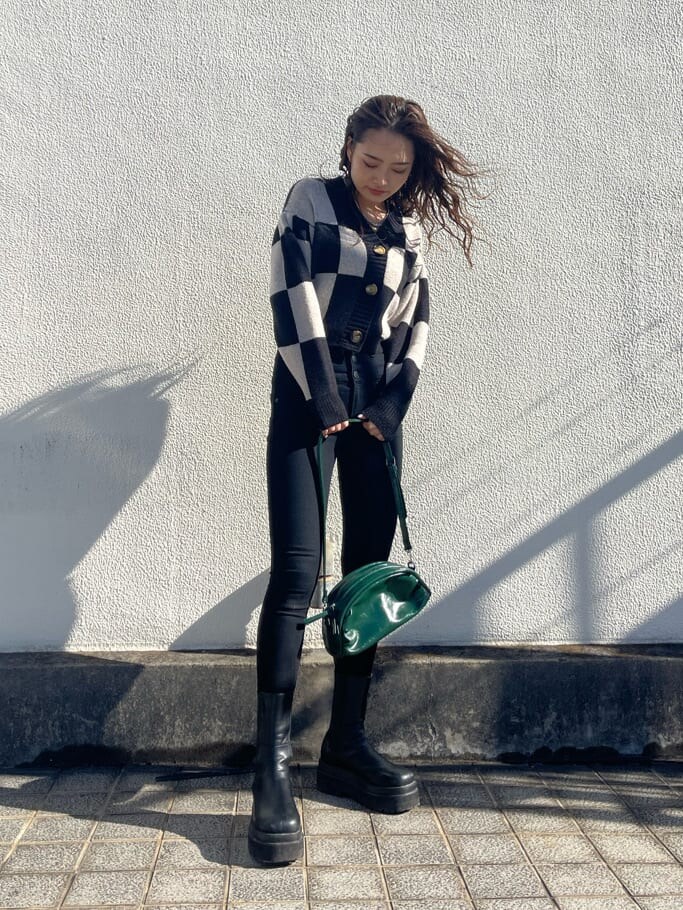 ブラック系のデニムパンツ、グリーン系のボディバッグ/ウエストポーチ、ブラック系のカーディガン/ボレロを着用したレディースの冬コーディネートの2枚目の写真