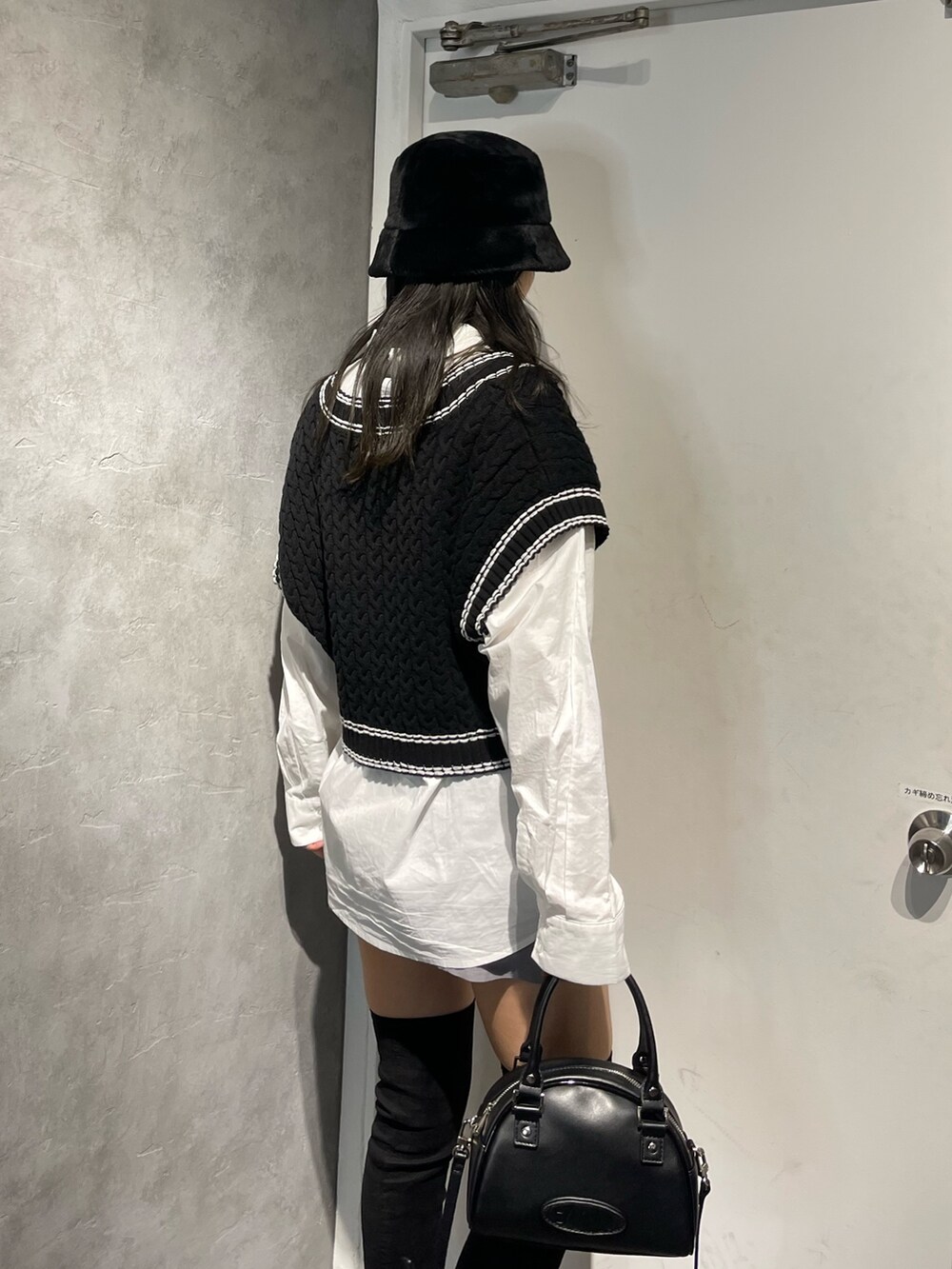 ブラック系のブーツ、ブラック系のベスト、ホワイト系のシャツ/ブラウスを着用したレディースの冬コーディネートの7枚目の写真